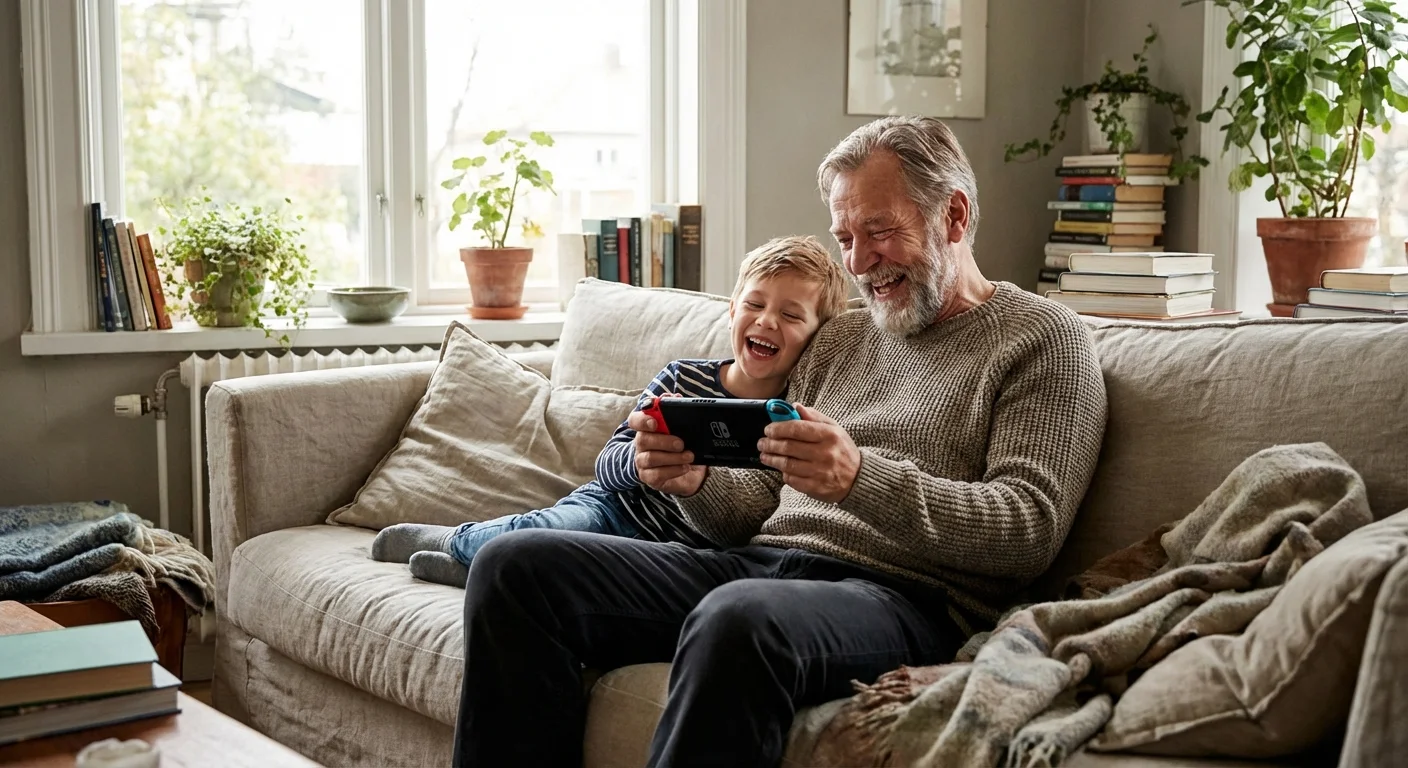 A grandfather and grandson playing a handheld game together on a sofa.