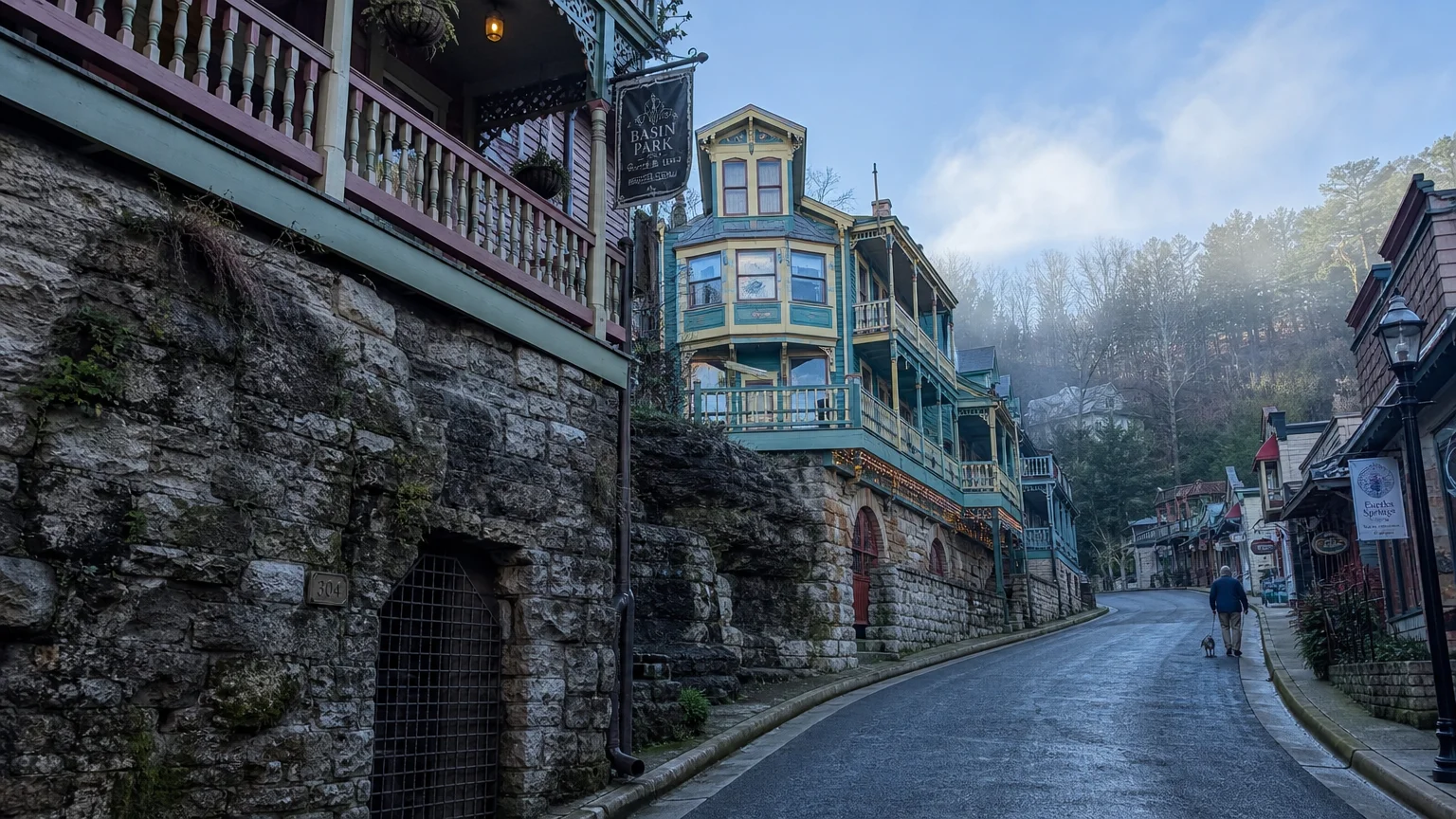 A winding street in Eureka Springs featuring colorful Victorian houses built into the hillside.